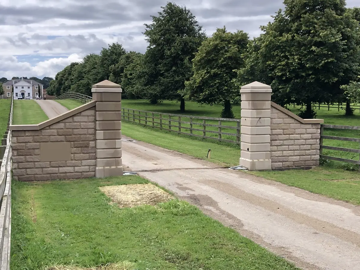 Dressed stone gate piers with parkland beyond